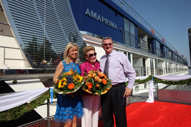 Kristin Karst (left), AmaWaterways' executive vice president, and Rudi Schreiner, president, photographed during a Bavarian christening ceremony of their new ship AmaPrima in Vilshofen, Germany. Kristin is presenting a present to AmaPrima godmother Valerie Wilson. © 2013 Ralph Grizzle