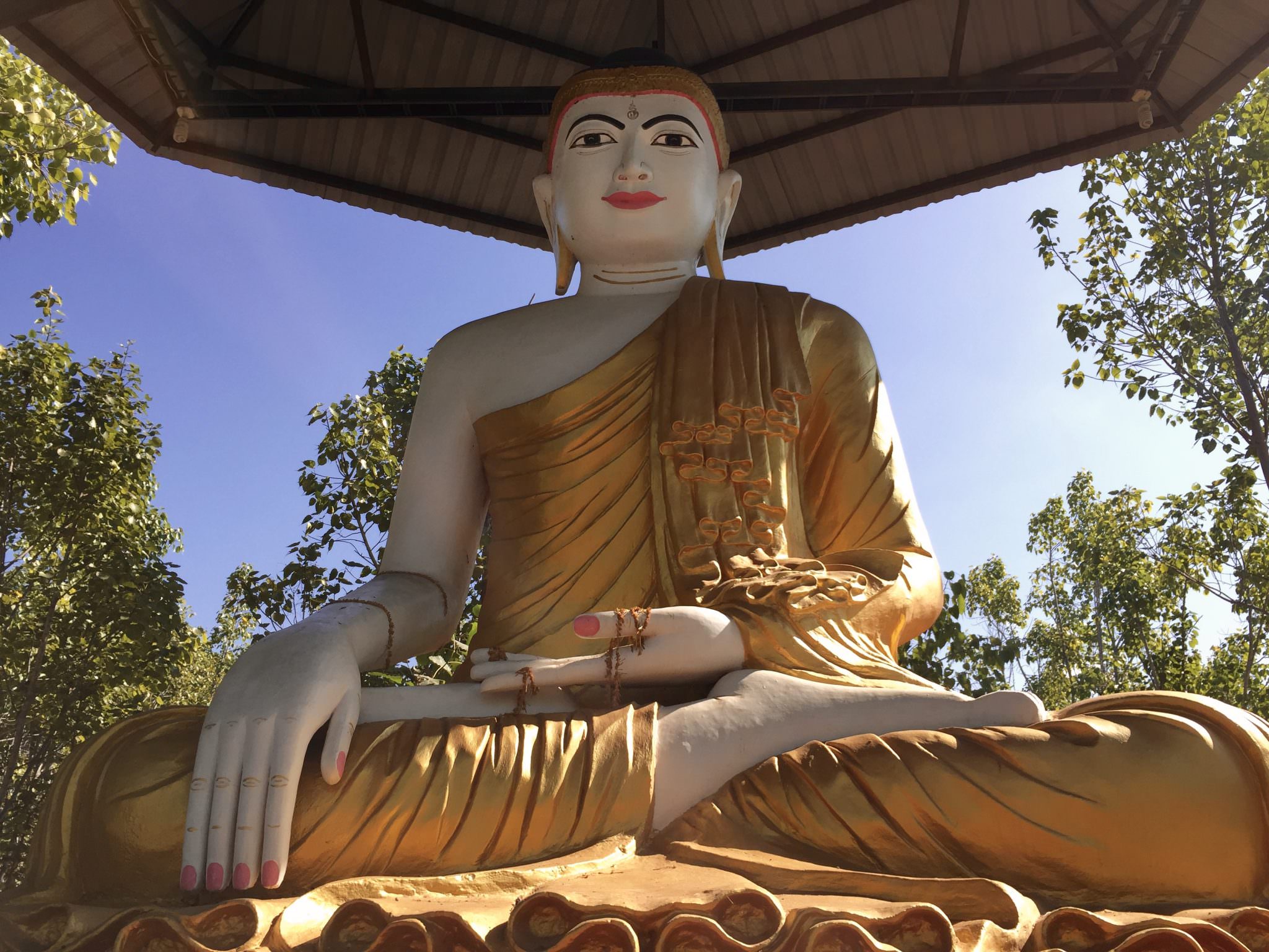 One central statue watches over the park. The mudra of this Buddha's hands symbolizes meditation (left) and not wavering from that practice by staying grounded under the bodhi tree until he achieves enlightenment (right). © 2015 Gail Jessen
