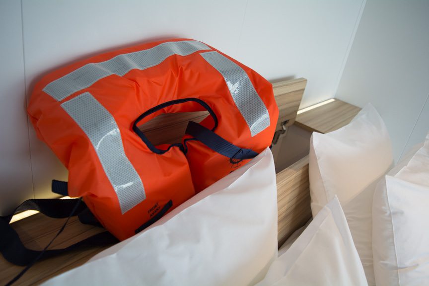 Lifejackets tuck cleverly into this cabinet mounted behind the headboard of the bed. Photo © 2016 Aaron Saunders